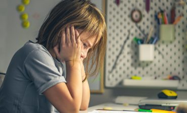 upset schoolgirl doing lessons, her homework. learning difficulties